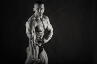 Karanlık bir arka plan üzerinde çok yardım vücut geliştirmeci.