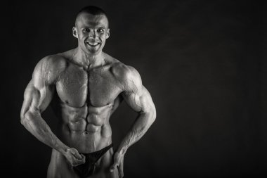 Karanlık bir arka plan üzerinde çok yardım vücut geliştirmeci.