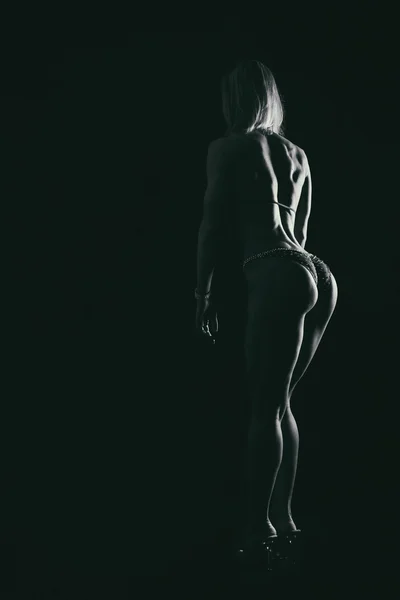 Schicker, sexy Bauch auf dunklem Hintergrund. — Stockfoto