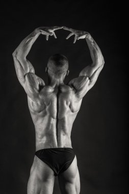 karanlık bir arka plan üzerinde güçlü vücut geliştirmeci.
