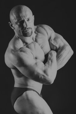 karanlık bir arka plan üzerinde erkek vücut geliştirmeci.