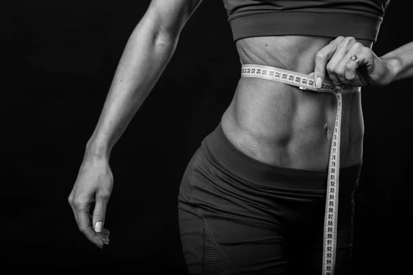 Female fitness on a dark background. — Stock Photo, Image