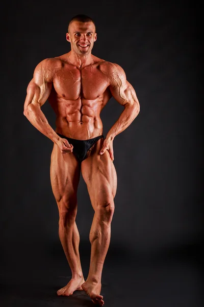 Bodybuilder på en mörk bakgrund. — Stockfoto