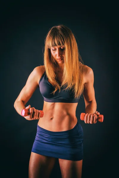 Female fitness on a dark background. — Stock Photo, Image