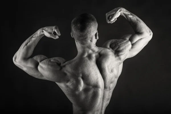 Stark bodybuilder på en mörk bakgrund. — Stockfoto