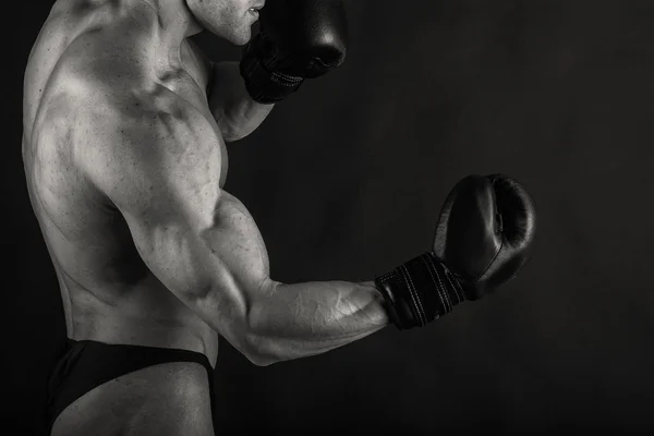 Karanlık bir arka plan üzerinde güçlü vücut geliştirmeci. — Stok fotoğraf