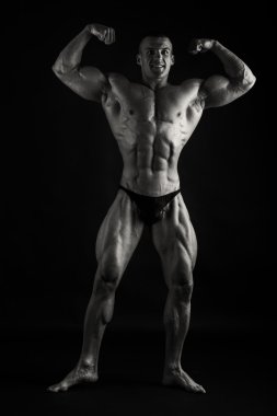 Karanlık bir arka plan üzerinde kas adam.