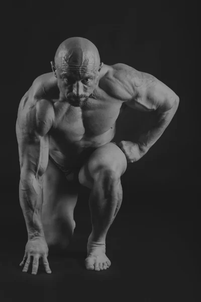 Männlicher Bodybuilder auf dunklem Hintergrund. — Stockfoto