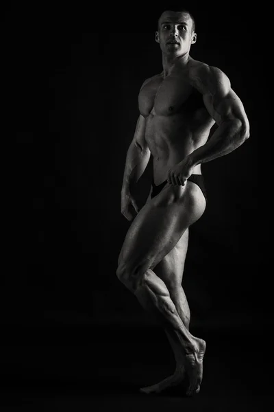 Muskularny mężczyzna na ciemnym tle. — Zdjęcie stockowe