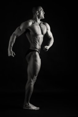 Karanlık bir arka plan üzerinde kas adam.