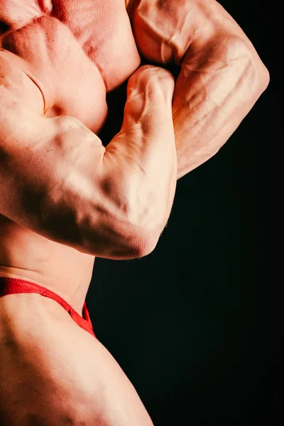 Fisiculturista muscular saudável em um fundo preto — Fotografia de Stock