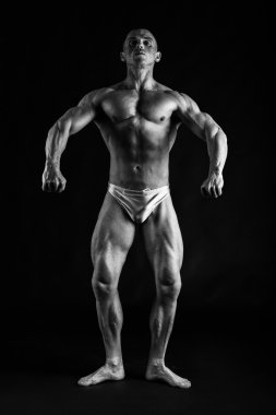 Karanlık bir arka plan üzerinde vücut geliştirmeci.