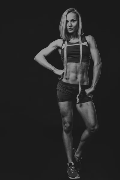 Atleta de fitness profesional sobre un fondo oscuro . — Foto de Stock