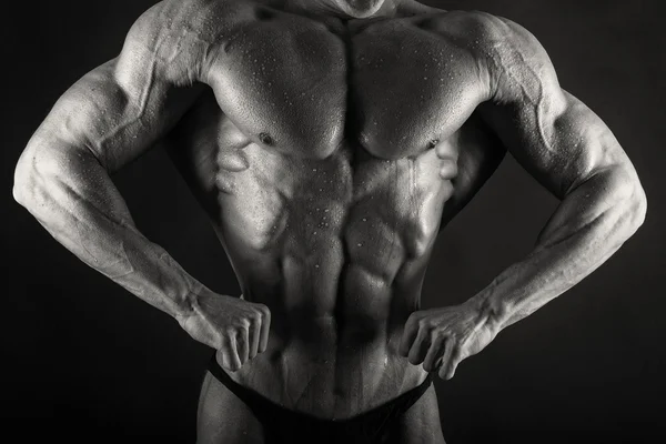 Zeer opluchting bodybuilder op een donkere achtergrond. — Stockfoto