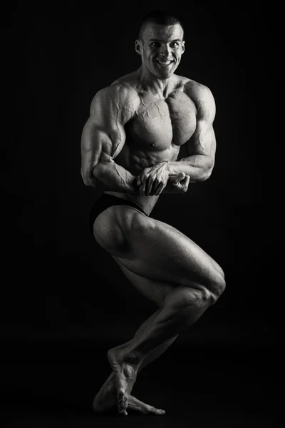 Hombre musculoso sobre un fondo oscuro . — Foto de Stock