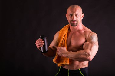 Bir adam siyah bir zemin üzerine muhteşem bir kas vücut ile