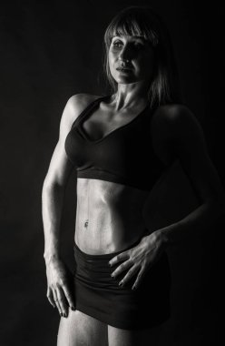 Zarif eğitim, kaslı kadın siyah bir zemin üzerine