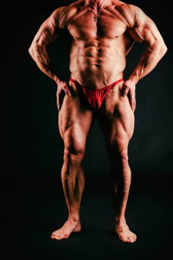 Bir adam siyah bir zemin üzerine muhteşem bir kas vücut ile