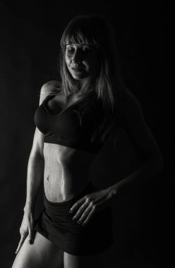 Zarif eğitim, kaslı kadın siyah bir zemin üzerine