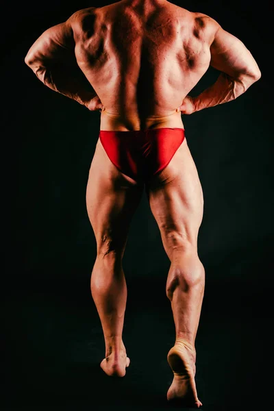Un hombre con un cuerpo musculoso magnífico sobre un fondo negro — Foto de Stock