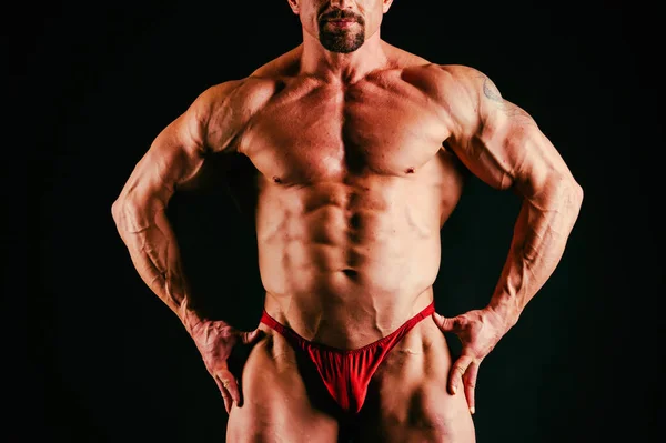 Un hombre con un cuerpo musculoso magnífico sobre un fondo negro —  Fotos de Stock