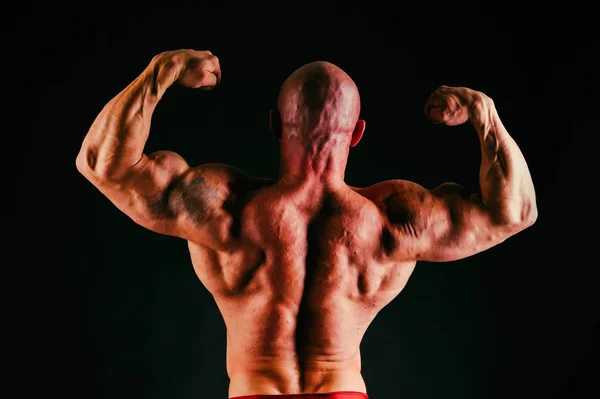 Человек с великолепным мускулистым телом на черном фоне — стоковое фото