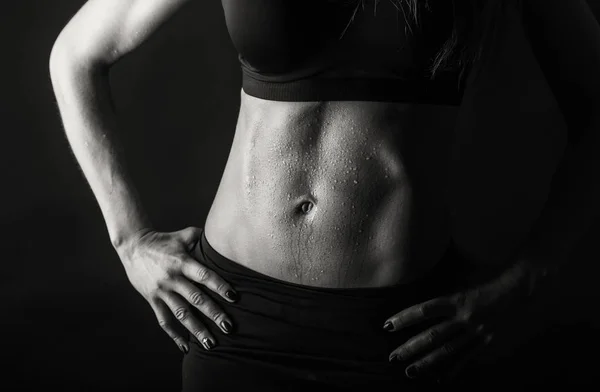 Elegantes Training, muskulöse Frau auf schwarzem Hintergrund — Stockfoto