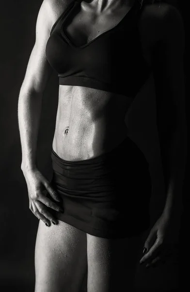 Elegant training, muscular woman on a black background — Stock Photo, Image