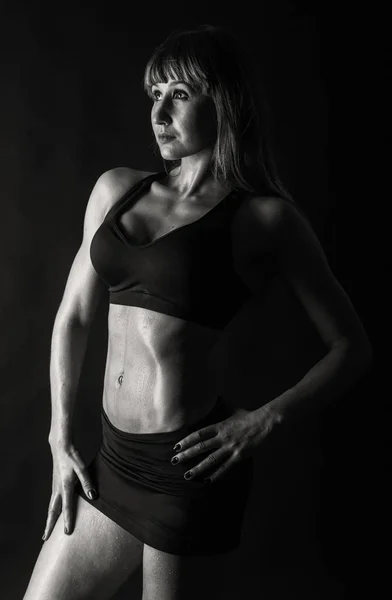 Κομψό κατάρτισης, μυϊκή γυναίκα, σε μαύρο φόντο — Φωτογραφία Αρχείου