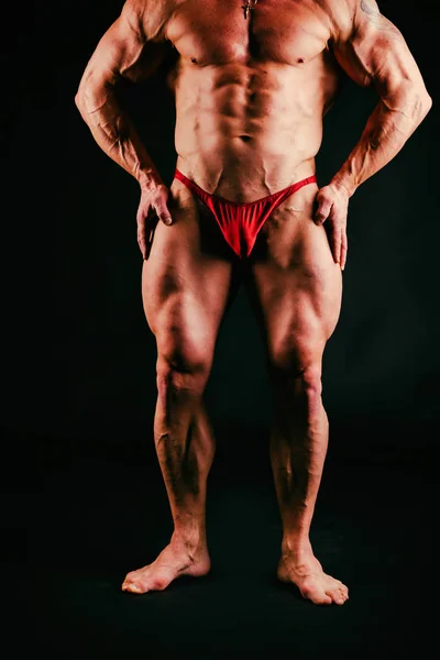Un hombre con un cuerpo musculoso magnífico sobre un fondo negro —  Fotos de Stock