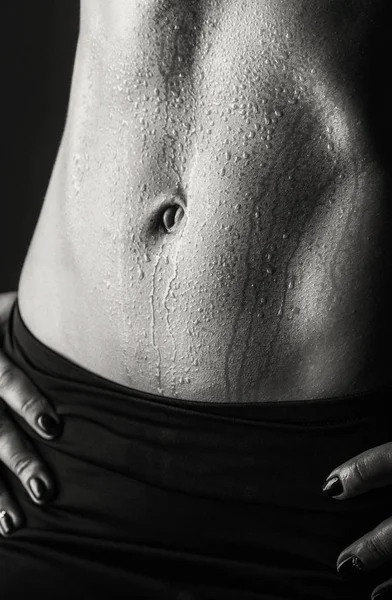 Entrenamiento elegante, mujer musculosa sobre un fondo negro —  Fotos de Stock