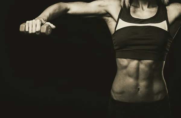 Female fitness. Sport girl on a dark background, black and white photo. — Stock Photo, Image