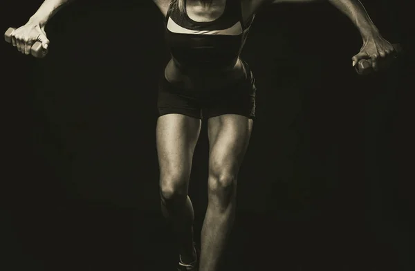 Aptidão feminina. Menina do esporte em um fundo escuro, foto em preto e branco . — Fotografia de Stock