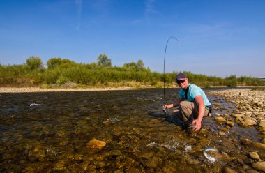 Dağ Nehri üzerinde Balık tutma. Kıyıdaki balıkçı. Yaz Ac