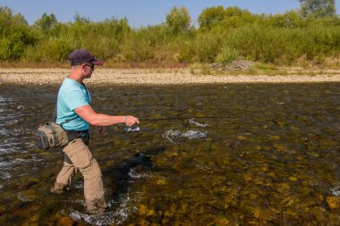 Dağ Nehri üzerinde Balık tutma. Kıyıdaki balıkçı. Yaz aktiviteleri. Balık tutma