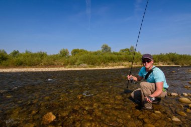 Dağ Nehri üzerinde Balık tutma. Kıyıdaki balıkçı. Yaz aktiviteleri. Balık tutma