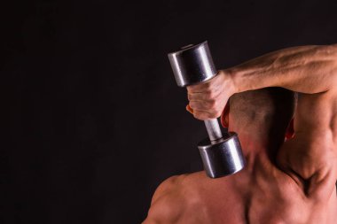 adam siyah bir zemin üzerine dumbbells ile