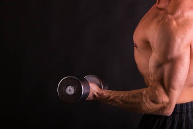 adam siyah bir zemin üzerine dumbbells ile