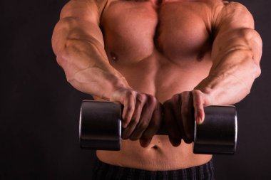 adam siyah bir zemin üzerine dumbbells ile