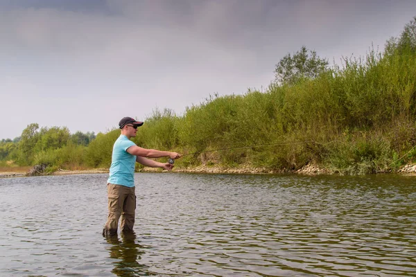 Pesca sul fiume di montagna. Pesca alla trota. Pescatore pesca nel — Foto Stock