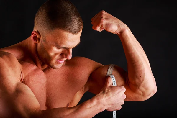 Strong bodybuilder on a black background — Stock Photo, Image