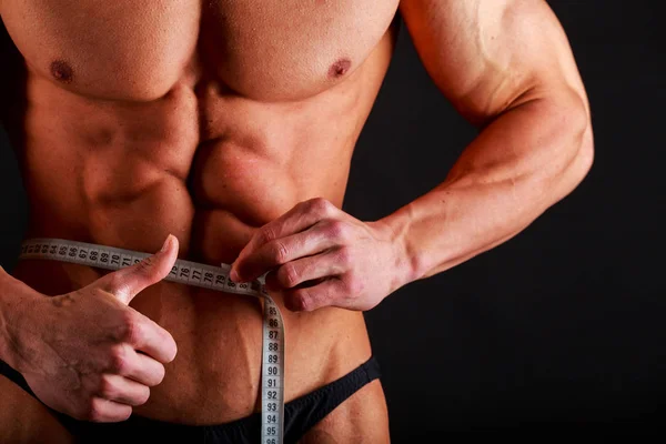 Sterke bodybuilder op een zwarte achtergrond — Stockfoto