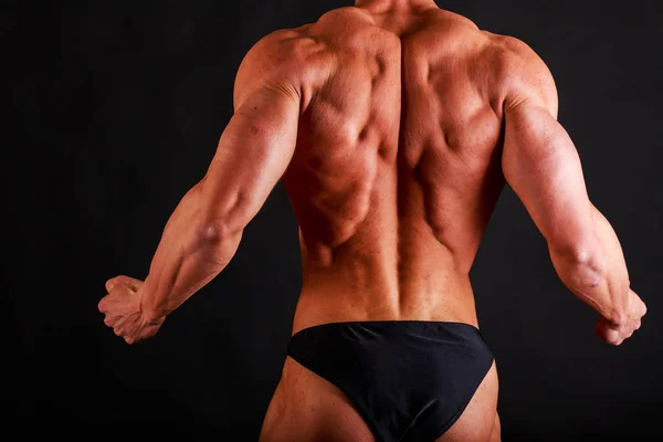 Sterke bodybuilder op een zwarte achtergrond — Stockfoto