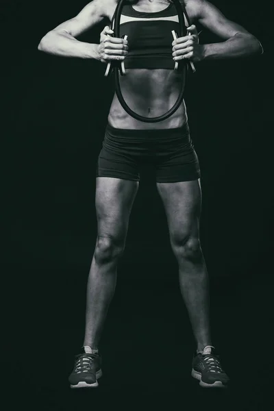 Aptidão feminina. Menina do esporte em um fundo escuro, foto em preto e branco . — Fotografia de Stock
