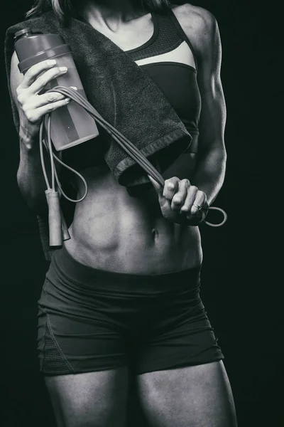 Kvinnlig kondition. Sport flicka på en mörk bakgrund, svart och vitt foto. — Stockfoto