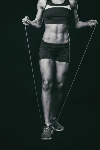 Aptidão feminina. Menina do esporte em um fundo escuro, foto em preto e branco . — Fotografia de Stock
