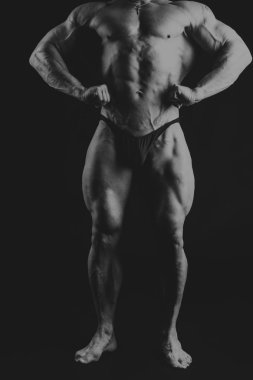 Bir adam siyah bir zemin üzerine muhteşem bir kas vücut ile