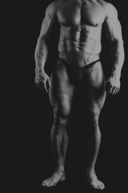 Bir adam siyah bir zemin üzerine muhteşem bir kas vücut ile