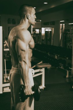 Genç adam spor salonunda antrenman yapıyor.