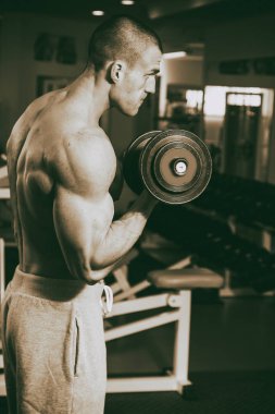 Genç adam spor salonunda antrenman yapıyor.